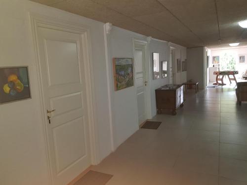 a hallway with white walls and a white door at Kyndestoft Bed & Breakfast in Holstebro