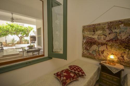 a bedroom with a couch and a window and a lamp at N’zina’s home in Custonaci