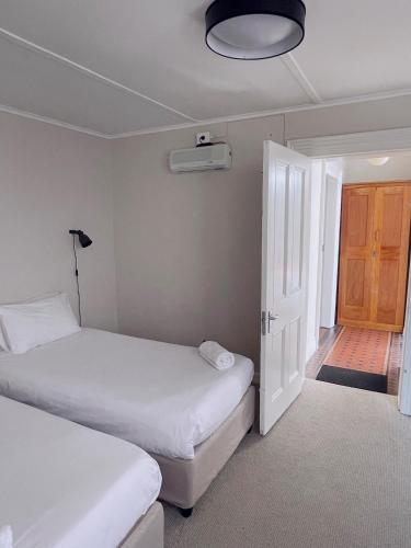 two beds in a room with a door and a bedroom at Villa Viva Cape Town in Cape Town