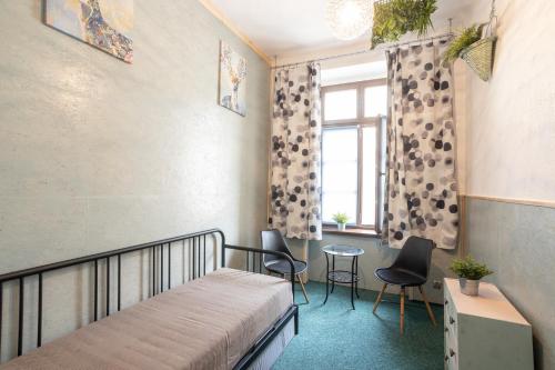sypialnia z łóżkiem, stołem i oknem w obiekcie Kościuszki Street Hostel we Wrocławiu