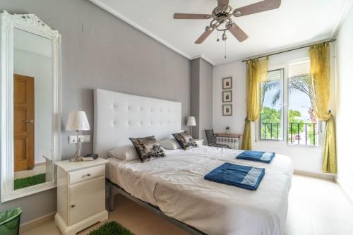 um quarto com uma cama, uma ventoinha de tecto e uma janela em Soleado Apartamento en Segunda Planta con Vistas a la Piscina en La Torre Golf - AE1422 em Torre-Pacheco