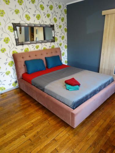 - une chambre dotée d'un grand lit avec des oreillers bleus et rouges dans l'établissement APPARTEMENTY COCO GUILBEAU, à Bourges