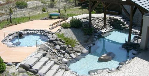 a backyard with a pool and a rock garden at Morinoyu Hotel Hanakagura in Asahikawa