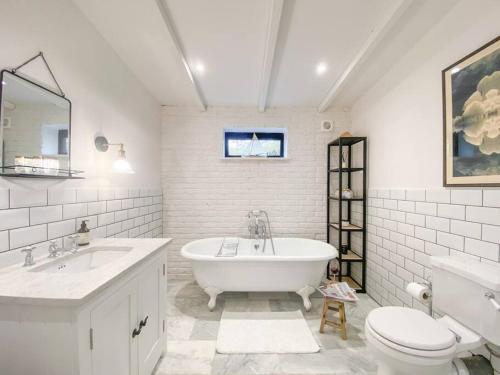 a bathroom with a tub and a sink and a toilet at Little Owl A beautiful bolt-hole for couples in Aldeburgh