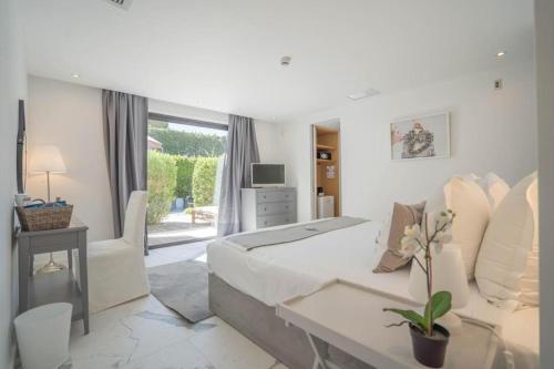 uma sala de estar branca com um sofá e uma mesa em Hotel le Mandala em Saint-Tropez