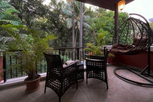 a balcony with two chairs and a swing at StayVista at Villa Arcadia with Alfresco Dining in Candolim