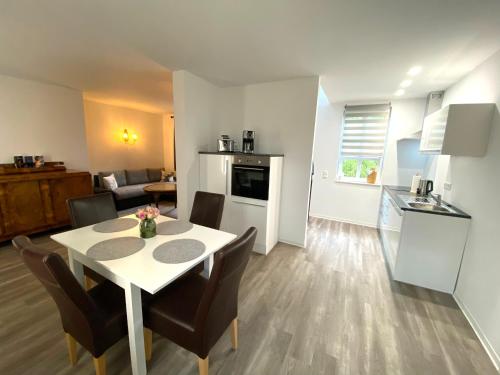 a kitchen and living room with a table and chairs at Ferienwohnungen zur alten PuppenFabrik in Sonneberg