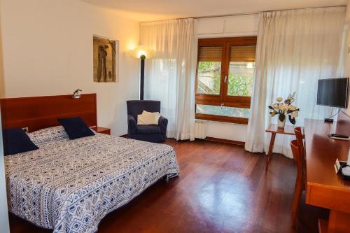 een slaapkamer met een bed, een bureau en een raam bij Marbela Apartments & Suites in Palermo
