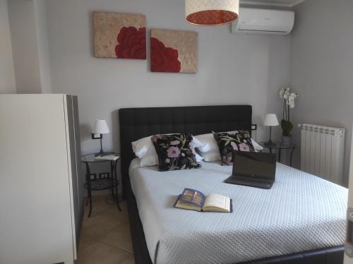 um quarto com uma cama, um computador portátil e livros. em Dreams House Paola-luxury suite near airport em Fiumicino