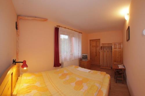 a small bedroom with a bed and a window at Pensiunea Tara in Vulcăneasa