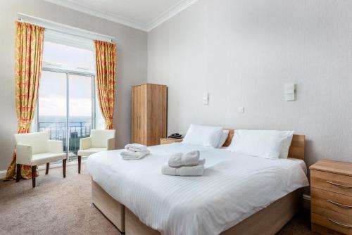 a bedroom with a bed and a large window at The Esplanade Hotel in Scarborough