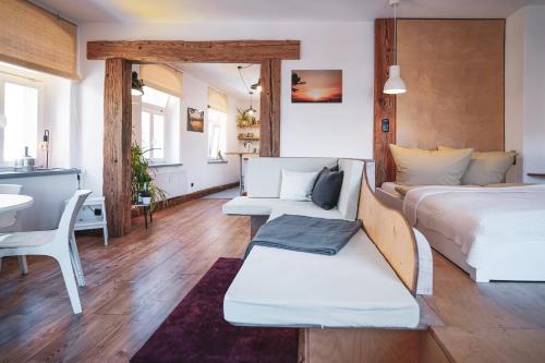a bedroom with a bed and a couch and a table at Studio Apartment zur alten Post, 48qm Individualapartment mit Blick über Zittaus Altstadt, Ferienwohnung im Altstadtkern umrandet vom Zittauer Gebirge in Zittau