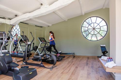a woman running on exercise bikes in a gym at Château de Berne in Lorgues