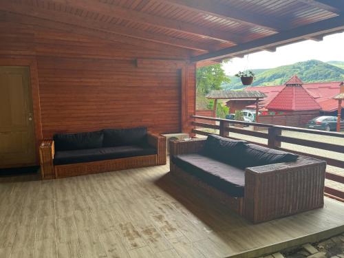 a patio with two couches on a deck at Casa Someseana in Gîlgău
