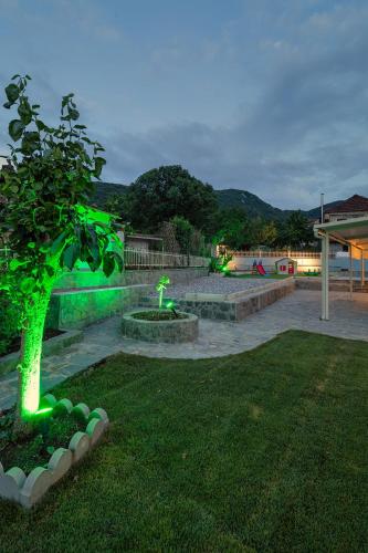 a park with a green tree in the grass at Bungalow Episkopiko in Ioannina
