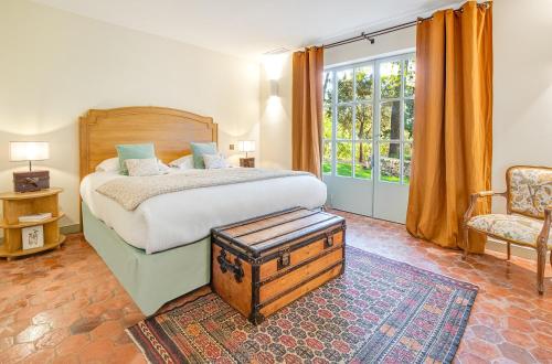 a bedroom with a bed and a chair and a window at Château de Berne in Lorgues