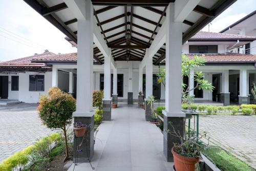 a building with white columns and plants in a courtyard at RedDoorz @ Avros Guest House Medan in Medan