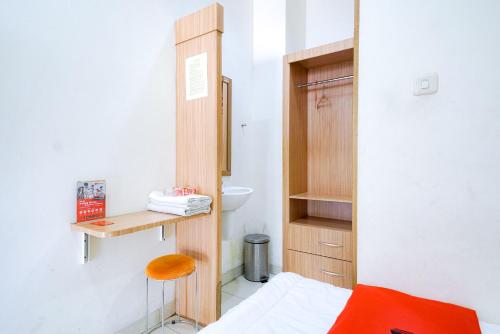 a small bathroom with a bed and a wooden cabinet at RedDoorz @ Avros Guest House Medan in Medan