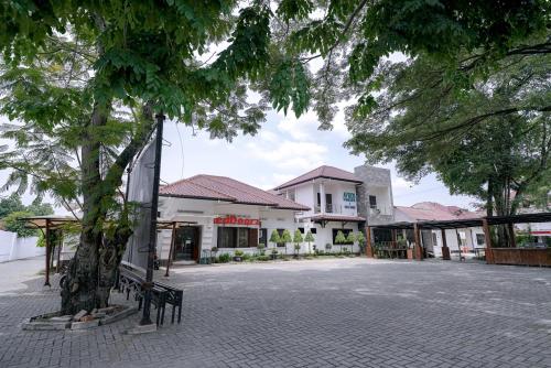 a building with a tree in the middle of a street at RedDoorz @ Avros Guest House Medan in Medan