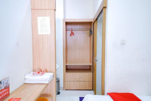 a room with a closet and a wooden door at RedDoorz @ Avros Guest House Medan in Medan