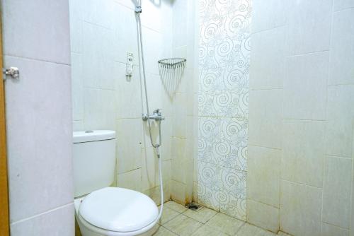 a bathroom with a toilet and a shower at RedDoorz @ Avros Guest House Medan in Medan