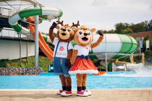 two people dressed in bear costumes standing in front of a water park at Apartments Terme Sveti Martin in Sveti Martin na Muri