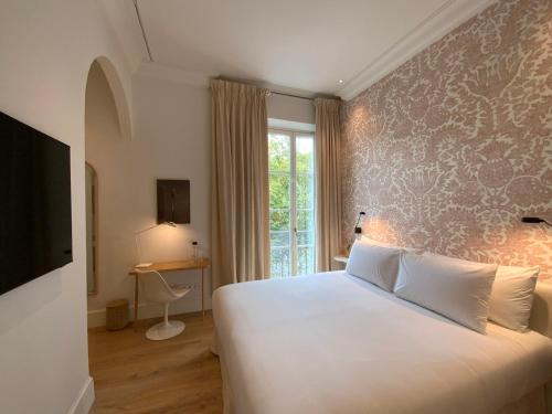 una camera d'albergo con letto e finestra di Hotel Tayko Sevilla a Siviglia