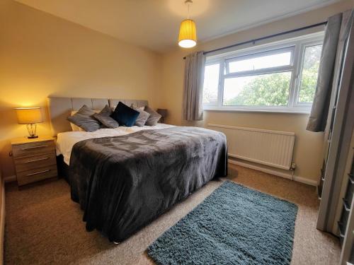 um quarto com uma cama grande e uma janela em Piping House 4bedroom em Otterbourne