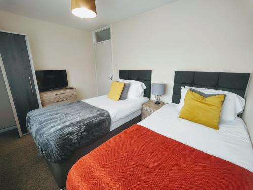 OtterbourneにあるPiping House 4bedroomのベッド2台、薄型テレビが備わるホテルルームです。