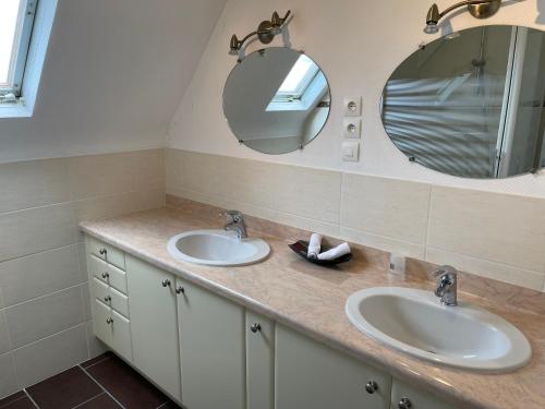 La salle de bains est pourvue de 2 lavabos et d'un miroir. dans l'établissement La Palmerais Dinard - 5 min de la plage, à Dinard