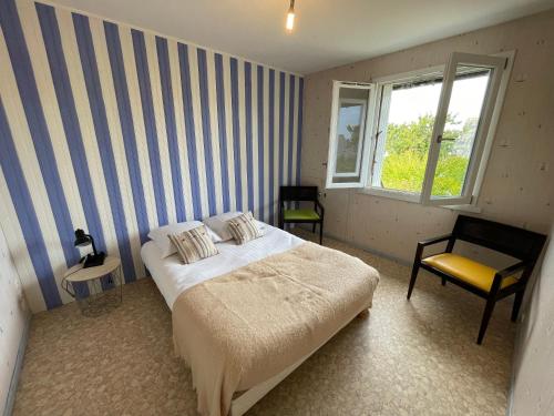 a bedroom with a bed and a chair and a window at La Palmerais Dinard - 5 min de la plage in Dinard