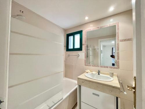 een badkamer met een douche, een wastafel en een spiegel bij La Concha - EaW Homes in Marbella