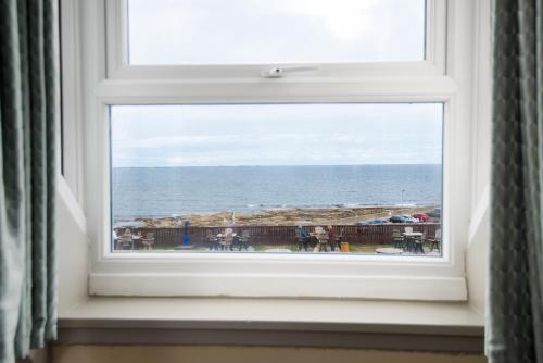 a window with a view of the ocean at The Bamburgh Castle Inn - The Inn Collection Group in Seahouses