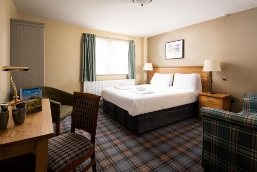 a hotel room with a bed and a table and chairs at The Bamburgh Castle Inn - The Inn Collection Group in Seahouses