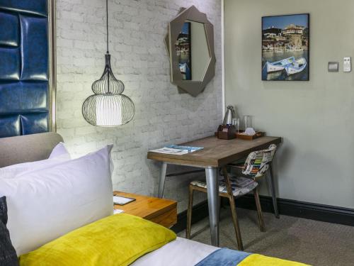 a bedroom with a desk and a bed and a table at Madamz Bed & Breakfast in Gaborone