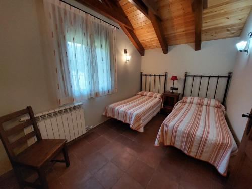 a bedroom with two beds and a window at Casa Moreno in Hospital