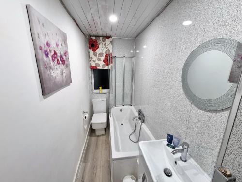 bagno con lavandino, servizi igienici e specchio di *12PR* Setup for your most relaxed & amazing stay + Free Parking + Free Fast WiFi * a Beeston Hill