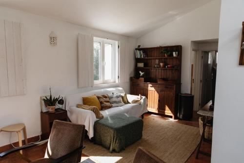 sala de estar con sofá blanco y ventana en Casa da Maria • Natural Côte • Aljezur, en Maria Vinagre