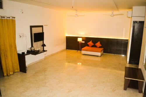 a living room with a couch and a television at The कस्तूरी in Maihar
