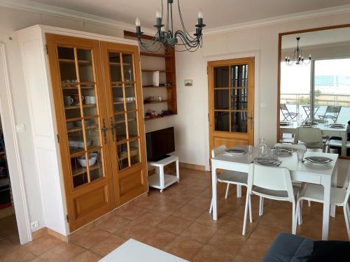une salle à manger avec une table et des chaises blanches dans l'établissement ST JEAN DE MONTS - VUE MER - 2 Chambres, à Saint-Jean-de-Monts
