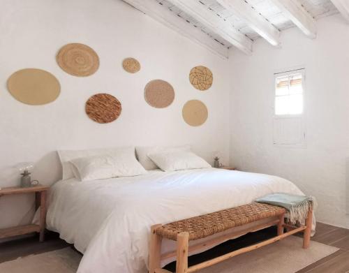 a bedroom with a bed with a bench in it at Casa El Olmo de Navajas in Navajas