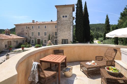a patio with a table and chairs and a building at Château de Berne in Lorgues