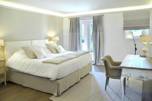a bedroom with a large bed and a desk and a desk at Château de Berne in Lorgues