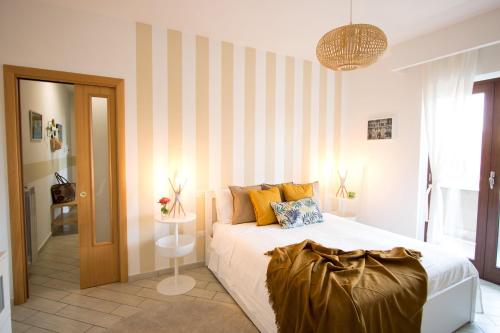 um quarto com uma cama e uma parede listrada em Casa Vivienne em San Vitaliano 