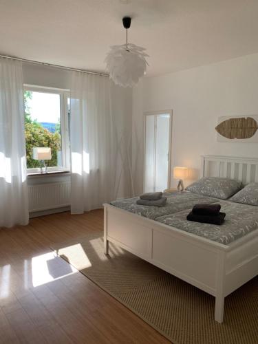 Un dormitorio con una cama grande y una ventana en Idyllische Stadtwohnung im Grünen, en Siegen