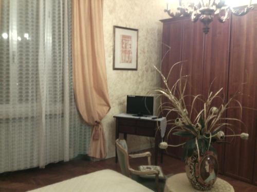 1 dormitorio con escritorio, ordenador y planta en B&B Alle Piscine Verona, en Verona