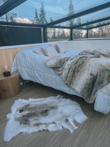 a bedroom with a large bed with a white comforter at Levi Sensu - Levi Sky Igloos in Levi