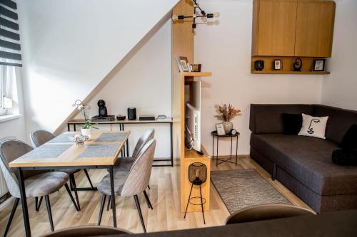 a living room with a table and a couch at Rose Gold Apartment in Zalaegerszeg