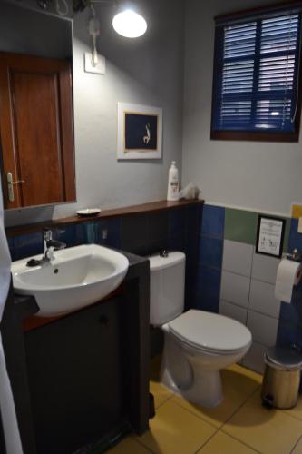 ein Badezimmer mit einem weißen WC und einem Waschbecken in der Unterkunft El Quinto Pino - El Estudio in Las Indias