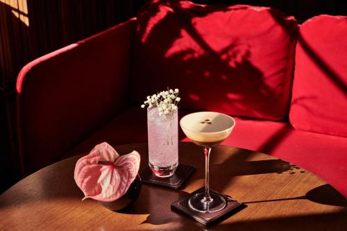 a table with a drink and a vase with flowers on it at Melia White House Hotel in London